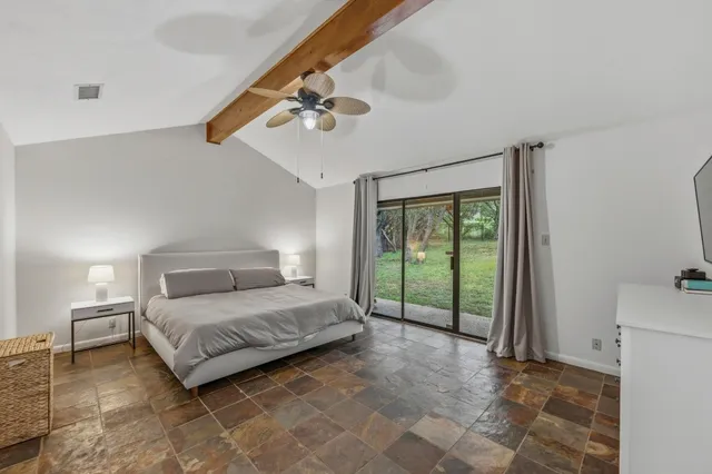 a spacious bedroom with a large bed and a chandelier