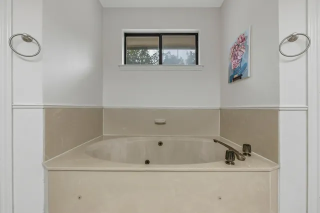 a bathroom with a tub and a window