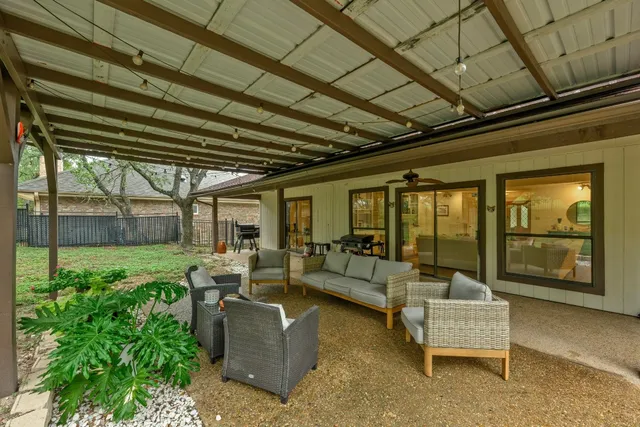 a living room with patio furniture and garden view