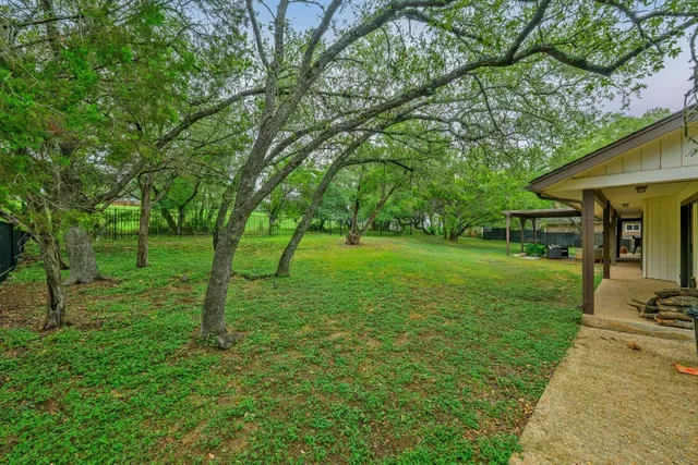 a view of a backyard with large trees