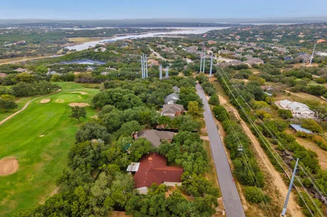 an aerial view of residential houses with outdoor space and trees
