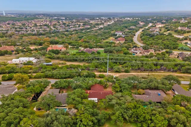 an aerial view of residential houses with outdoor space and trees