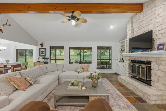 a living room with furniture a fireplace and a flat screen tv