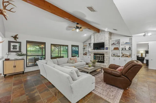 a living room with furniture flat screen tv and a large window