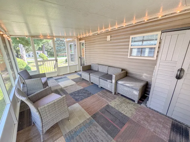 a living room with furniture a flat screen tv and floor to ceiling window