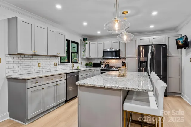 a kitchen with stainless steel appliances granite countertop a sink refrigerator and cabinets