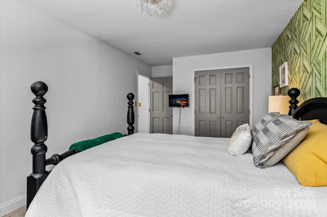 a bedroom with a bed and a chandelier