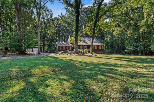 a view of a house with a big yard and sitting area