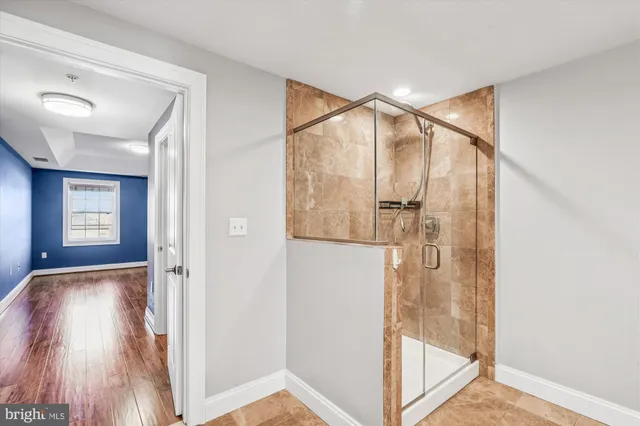 a bathroom with a glass shower door and mirror