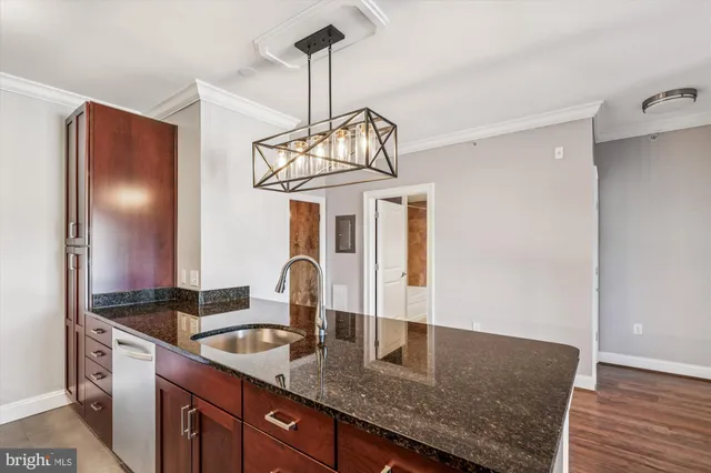 a kitchen with granite countertop a sink stainless steel appliances and cabinets