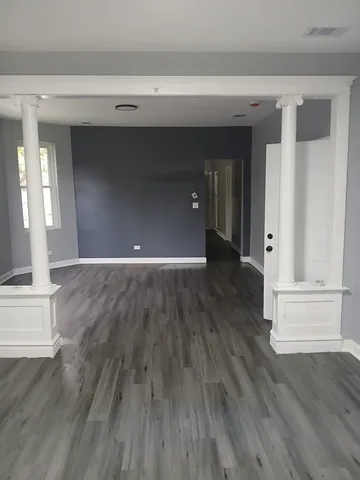 a view of a hallway with wooden floor and closet