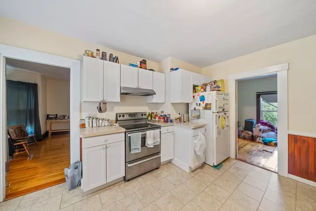 a kitchen with white cabinets and white appliances