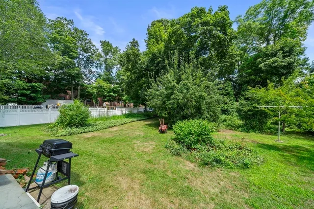 a view of a chair and table in backyard of the house