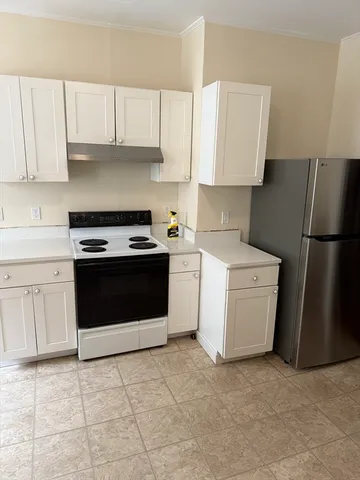 a kitchen with a stove top oven and cabinets