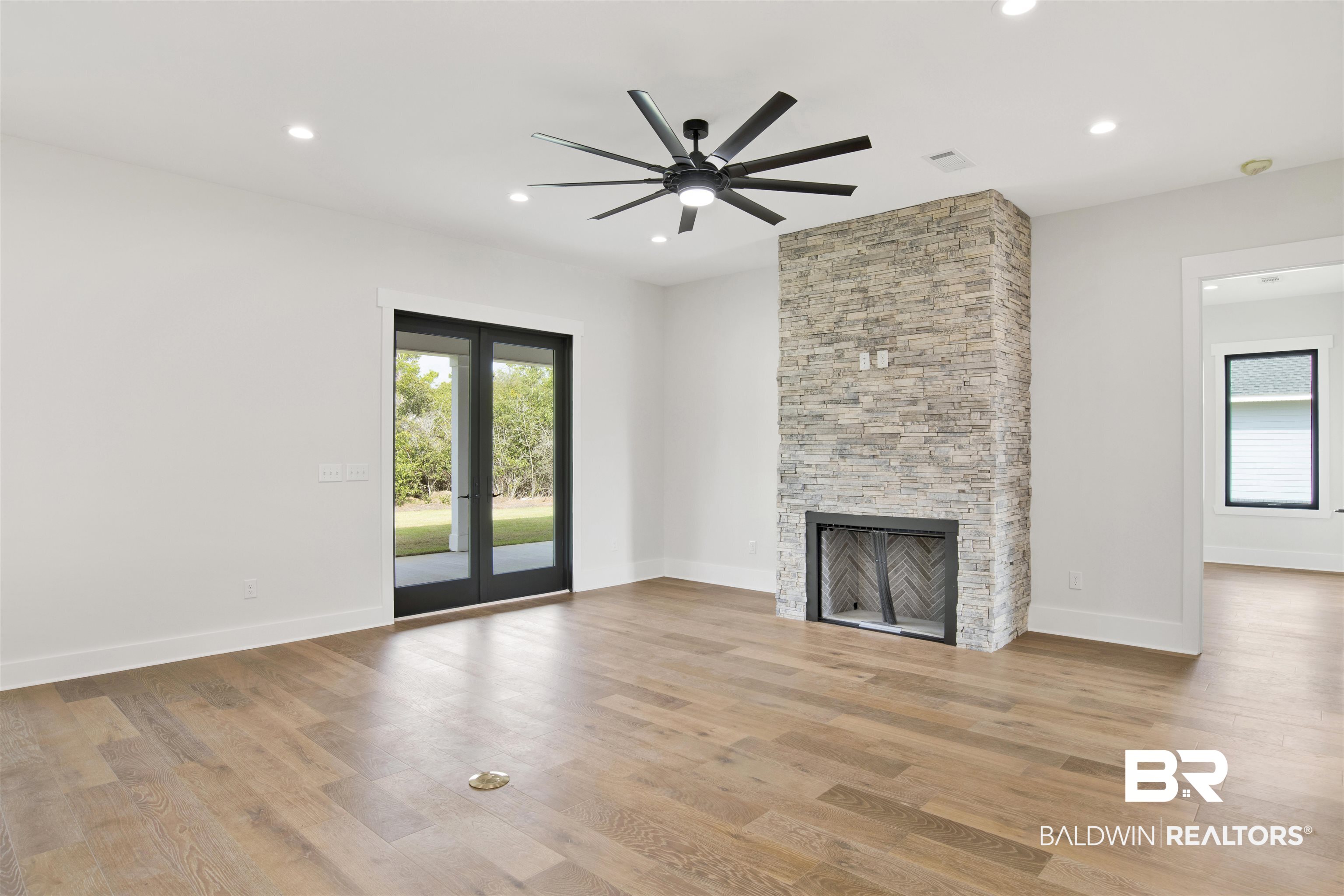 31545 River Road Orange Beach, AL 36561 - Photo 8 of 59 Living room featuring ceiling fan, engineered wood flooring and stone surround fireplace