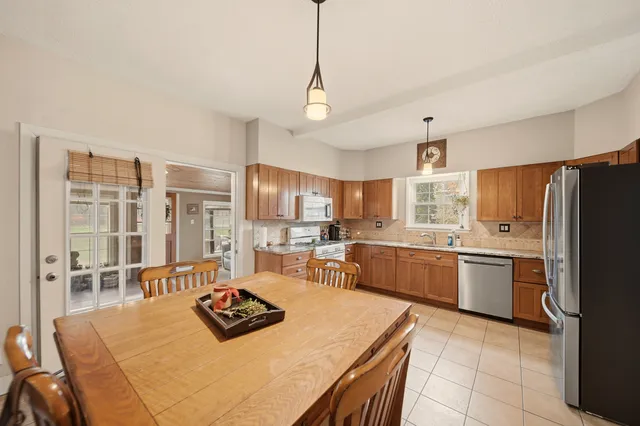 a kitchen with a refrigerator a stove top oven a sink dishwasher and white cabinets with wooden floor