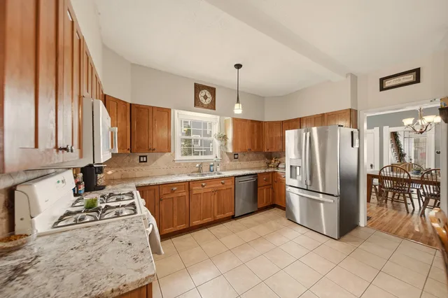 a kitchen with granite countertop a refrigerator and a stove top oven