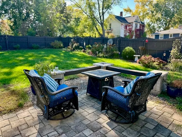 a view of a chairs and table in backyard