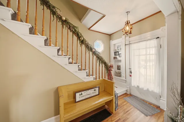 a view of staircase with lots of frames on wall and a window