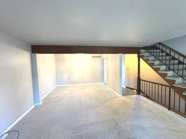 a view of a big room with wooden floor and windows