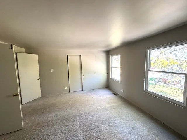 an empty room with windows and closet