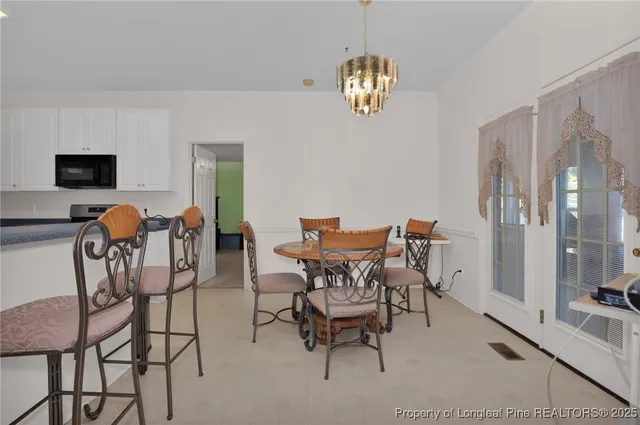a view of a dining room with furniture and chandelier