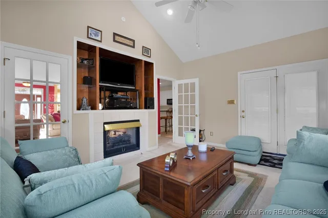 a living room with furniture a flat screen tv and a fireplace