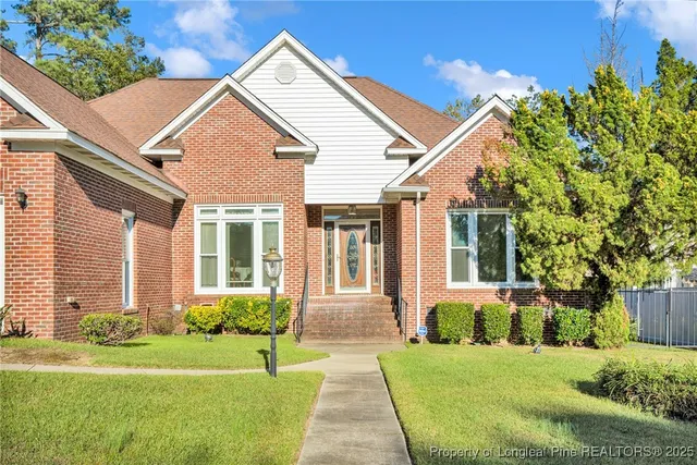 a front view of a house with a yard and potted plants