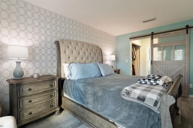 a bedroom with a bed and a lamp on dresser