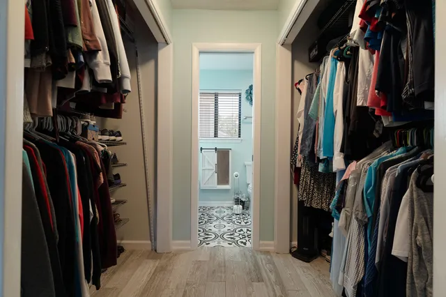 a view of walk in closet with clothes and shoes