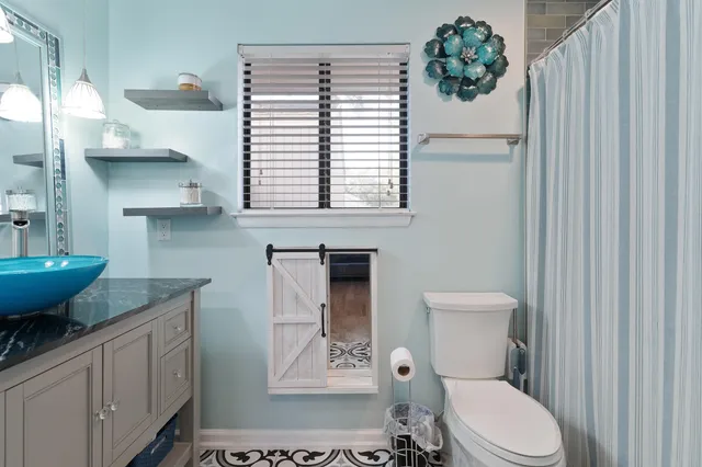 a bathroom with a toilet a sink and mirror