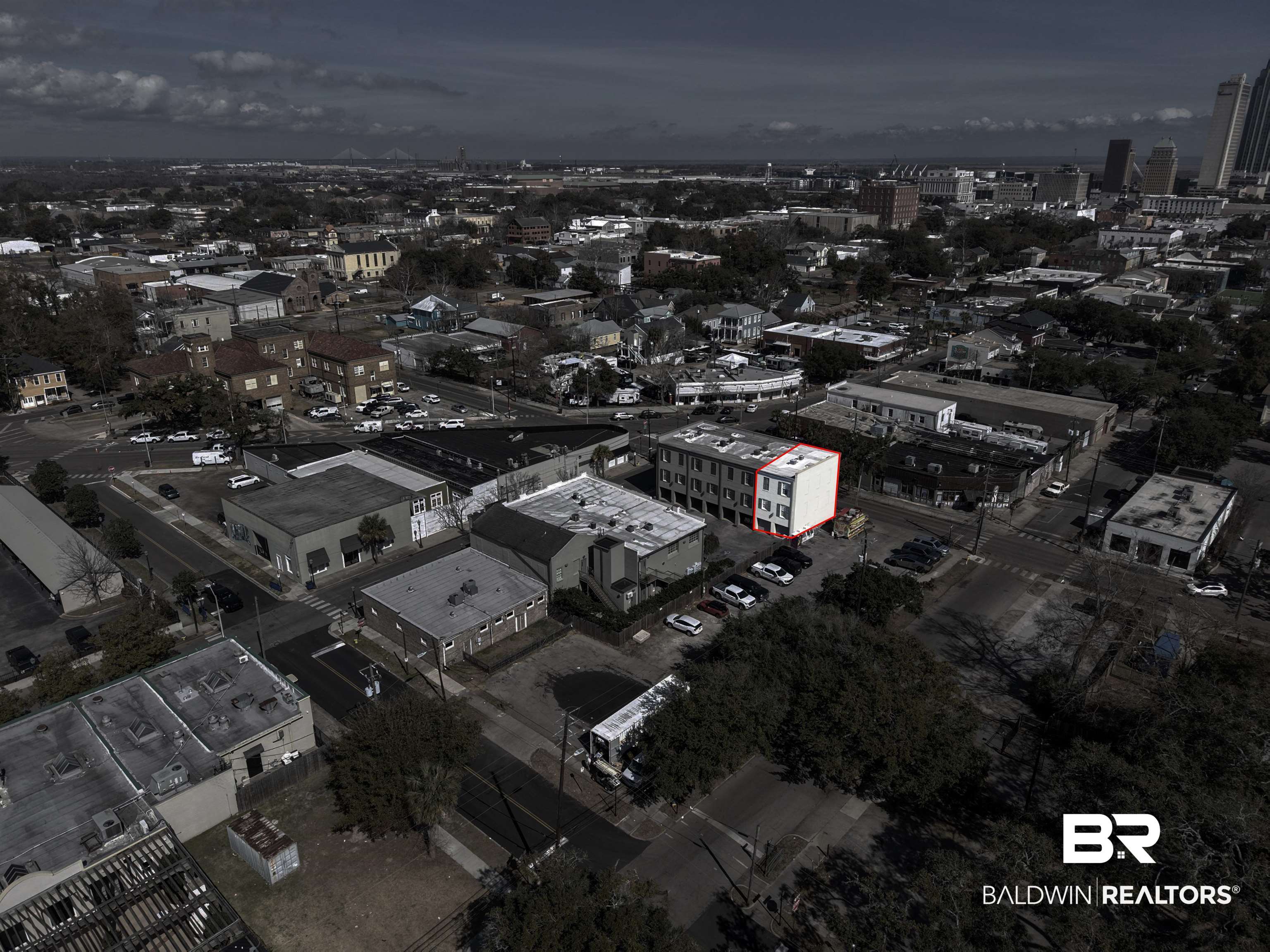 701 Dauphin Street, Unit A Mobile, AL 36602 - Photo 27 of 31 Multi-story building featuring a light-colored facade with window openings and a darker side elevation