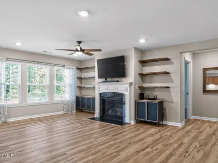 a view of an empty room with a fireplace and a window