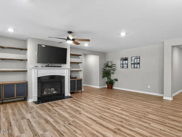 a view of a livingroom with a fireplace a flat screen tv and staircase