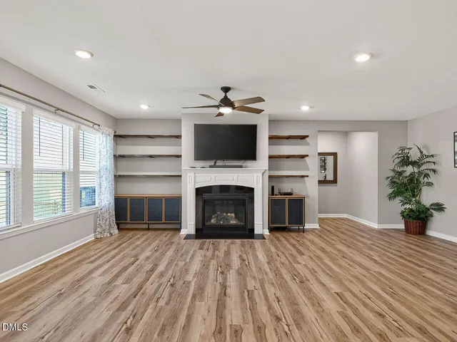 a living room with a fireplace and a floor to ceiling window
