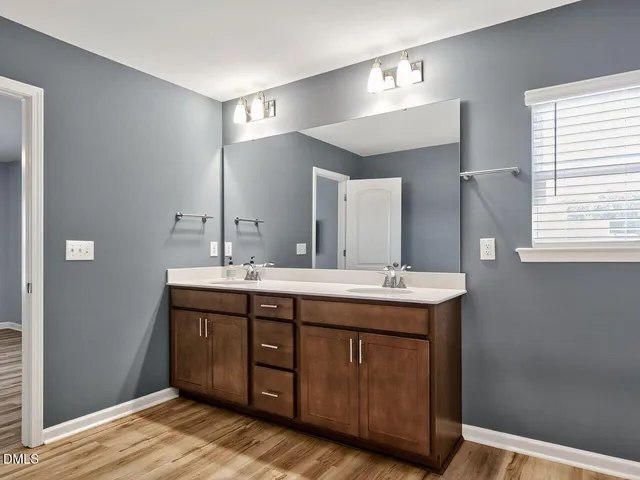 a bathroom with a double vanity sink and a mirror