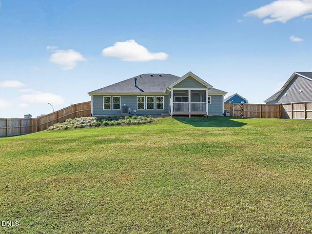 a view of a house with a big yard and large trees