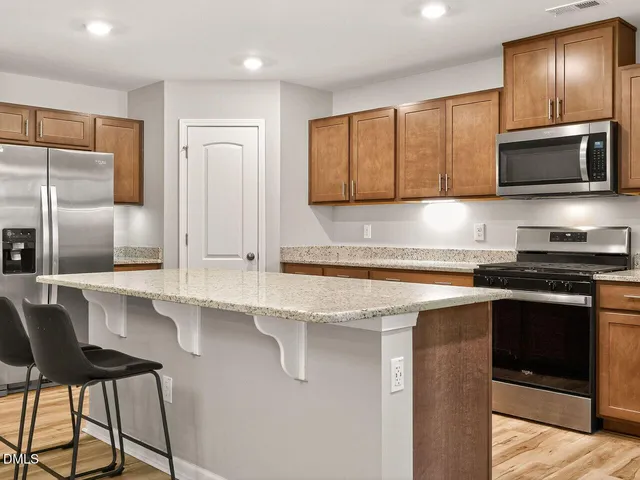 a kitchen with stainless steel appliances granite countertop a sink and a stove