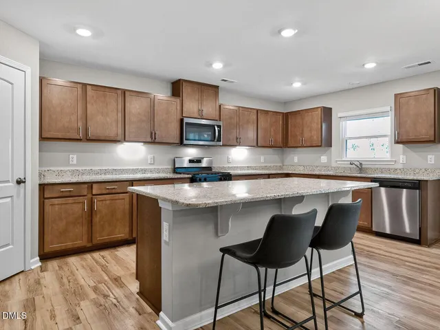 a kitchen with kitchen island granite countertop wooden cabinets and a granite counter tops