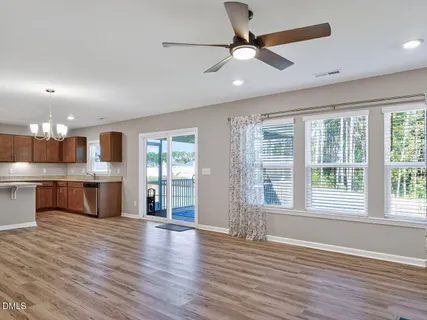 a view of an empty room with a kitchen and wooden floor