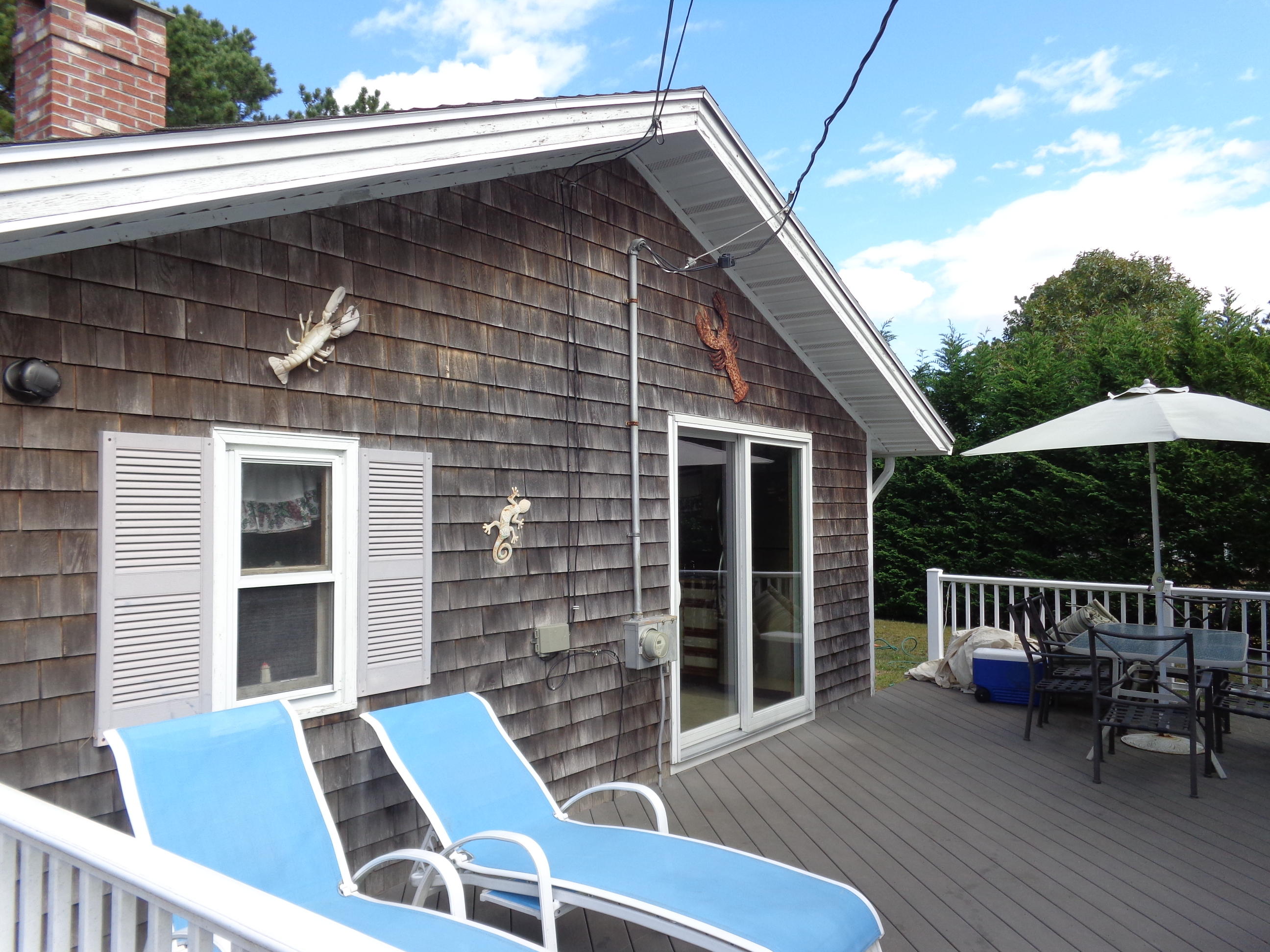 6 Huckleberry Lane Dennis Port, MA 02639 - Photo 2 of 23 a backyard of a house with wooden deck and furniture