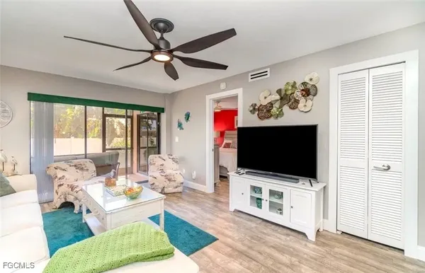 a living room with a flat screen tv a rug and a window