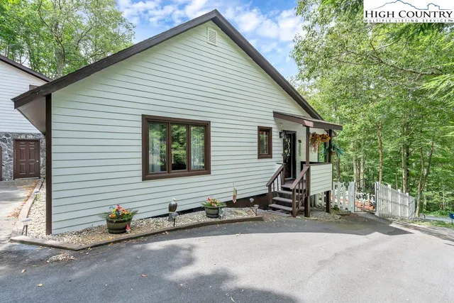 a view of a house with a yard and large tree