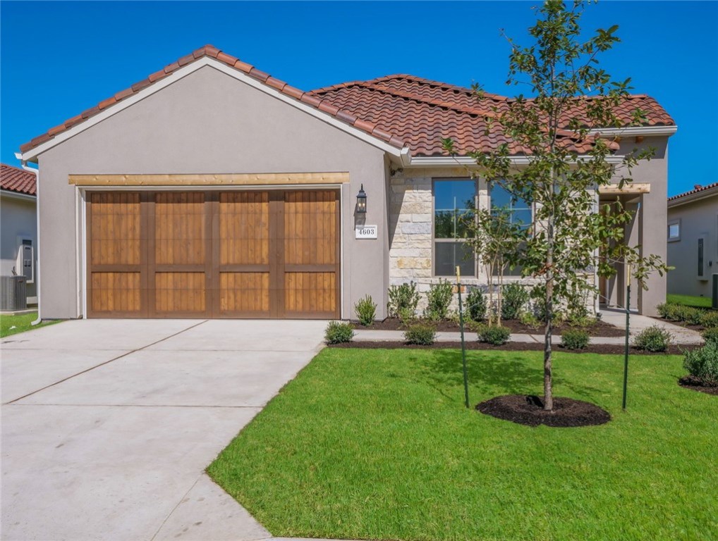a front view of a house with a garden and yard