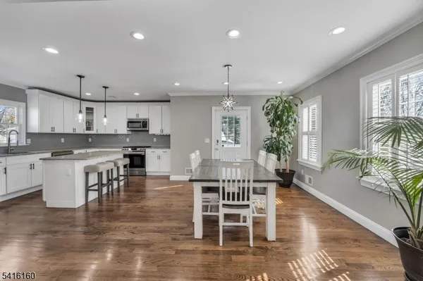 a kitchen with stainless steel appliances kitchen island granite countertop a stove top oven a dining table and chairs