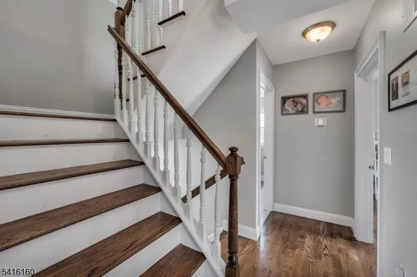 a view of staircase with wooden floor and white walls