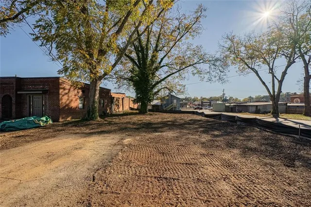 a view of dirt yard with a large trees