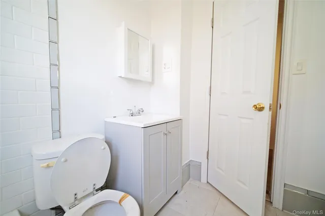 a bathroom with a toilet a sink and mirror
