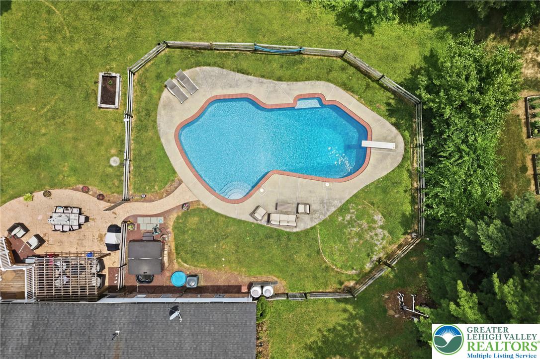 732 Bushkill Center Road Nazareth, PA 18064 - Photo 36 of 43 An aerial view captures the inviting pool area, complete with a surrounding patio and adjacent green spaces.