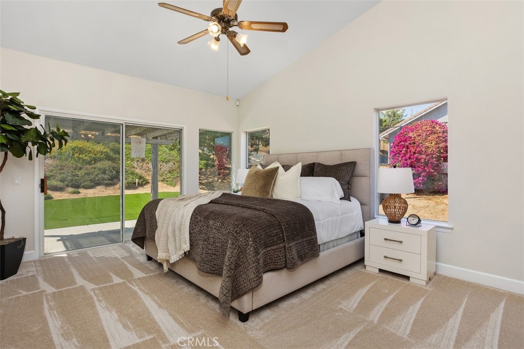 1795 Palomares Road Fallbrook, CA 92028 - Photo 19 of 37 a bedroom with a bed a chandelier and a large window